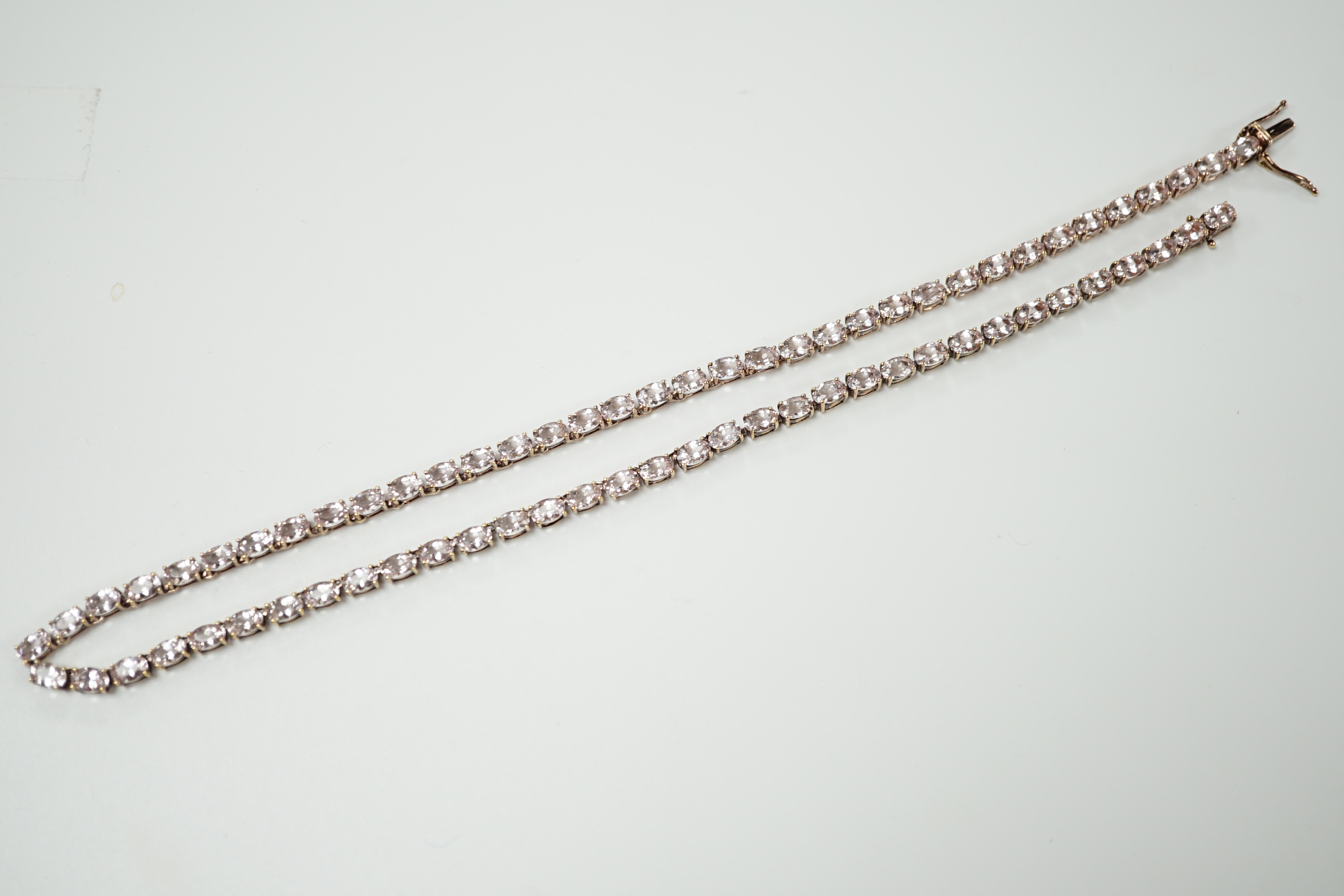 A modern 925 gilt metal and oval cut morganite set line necklace, 46cm.